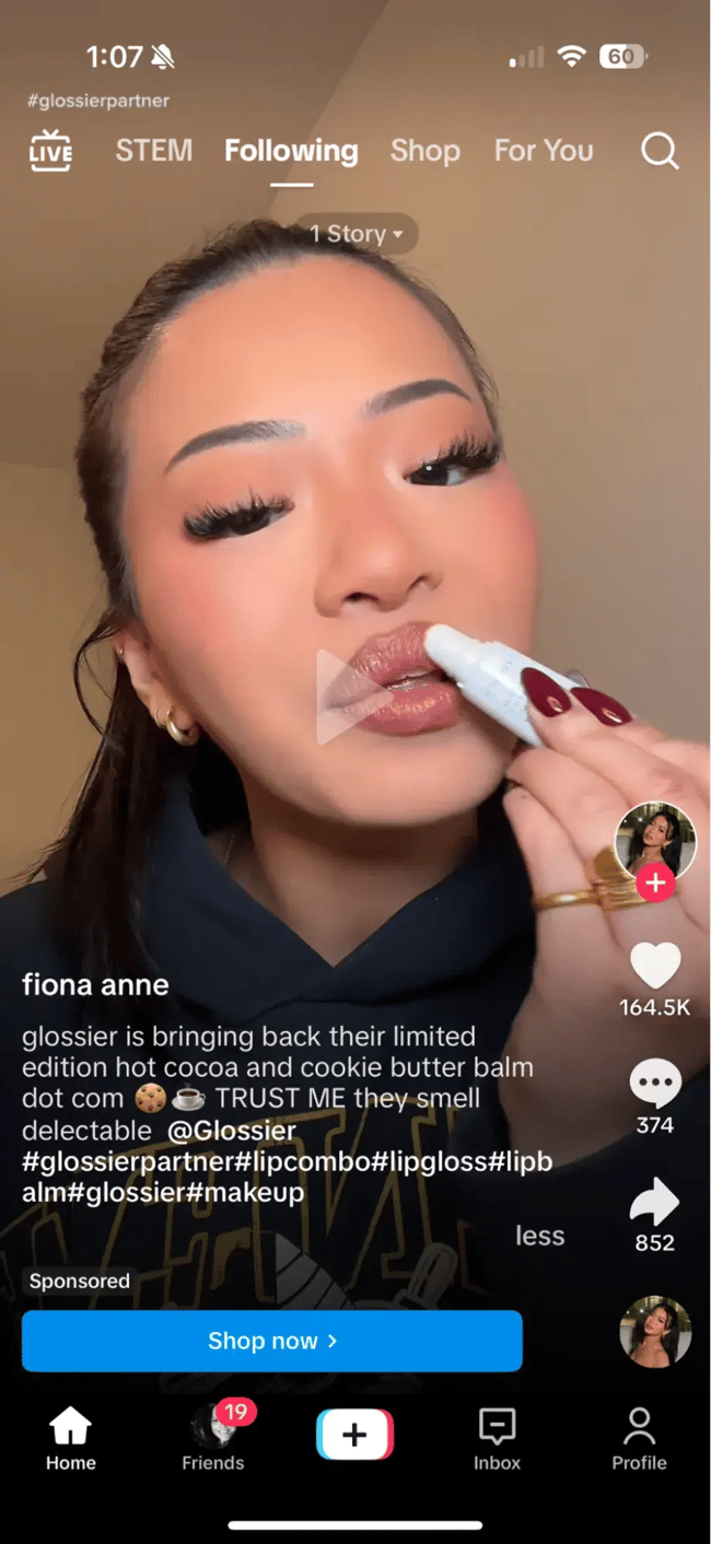 Screenshot showing an example of a Glossier TikTok ad with a blue call-to-action button